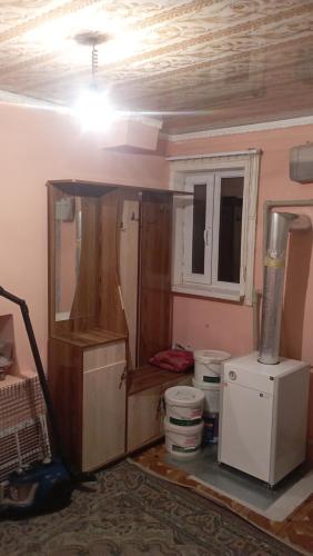 um quarto com uma cozinha com um fogão e um frigorífico em Жилой дом em Aralʼsk