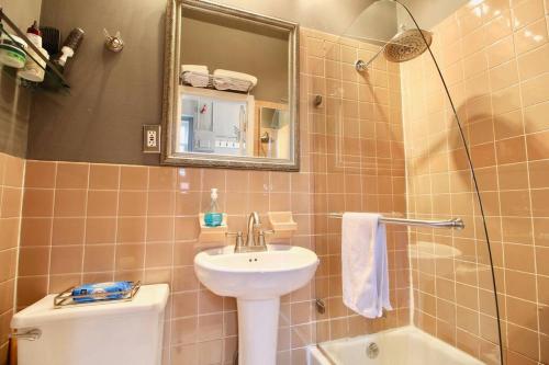 La salle de bains est pourvue d'un lavabo, de toilettes et d'un miroir. dans l'établissement The West Village Gem, à New York