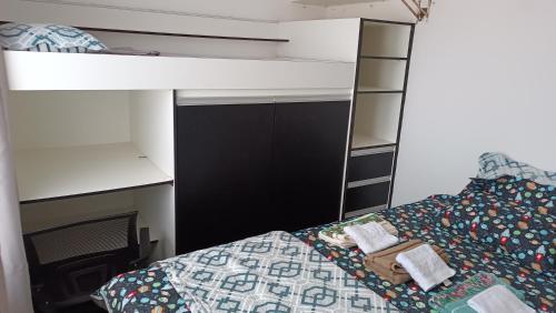 um quarto com uma cama e um beliche branco em House praia em São José de Ribamar