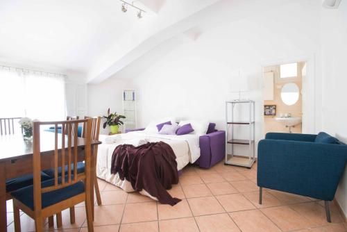 um quarto com uma cama e uma cadeira azul em CaseOspitali - Daisy, ampio trilocale x6 vicino a Piazza Maggiore em Bolonha