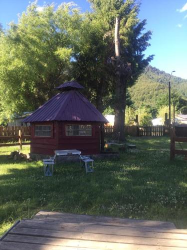 a small cabin with a purple roof in the grass at Mapunre in Malalcahuello