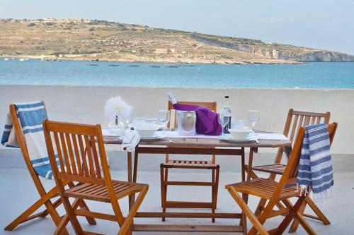 - une table sur la plage avec une table et des chaises dans l'établissement THE AUTHENTIC TOWNHOUSE, à San Pawl il-Baħar