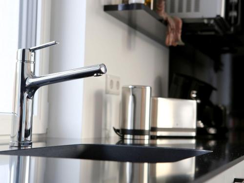 a kitchen counter with a sink and a faucet at Purer Genuss - 110qm in Owingen