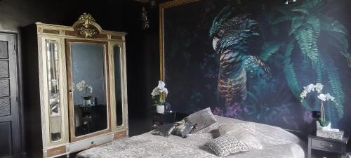 um quarto com uma pintura de um dragão na parede em La belle étoile em Bouniagues