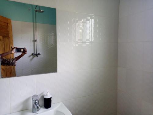 een persoon die een foto neemt van een douche in een badkamer bij JM ACCOMMODATIONs in Watamu