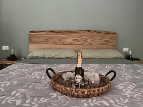 a bottle of champagne in a basket on a bed at Il Bosco Incantato in Borgo San Dalmazzo