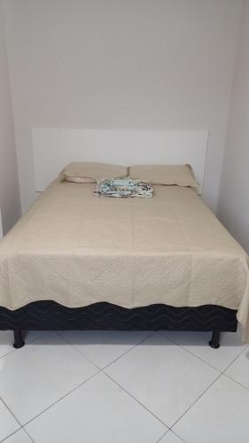 Cama en habitación con suelo blanco en Apto em Marataízes-ES, 03 quartos e 02 banheiros, en Marataízes