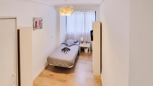 um pequeno quarto com uma cama e uma janela em Exclusive Guest Room Experience in Cozy & Modern Apartment - No other guests em Valência