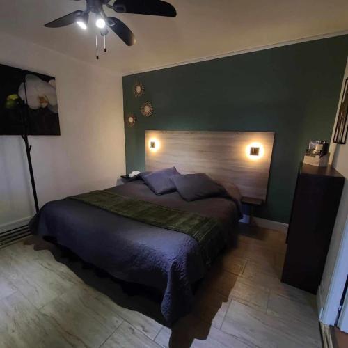 une chambre avec un grand lit et un ventilateur de plafond dans l'établissement Gîte La Dolce Vita du Perigord, à Bergerac