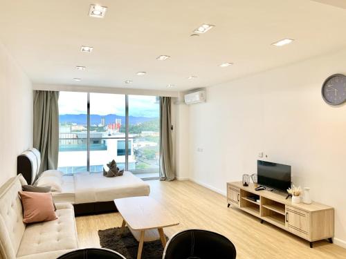 a living room with a couch and a tv at Deco Home @ Aru Suites in Kota Kinabalu