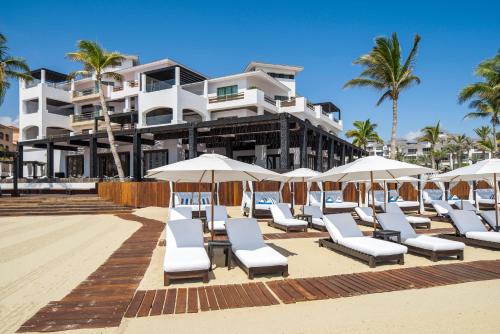 a row of lounge chairs and umbrellas on a beach at Hilton Vacation Club Cabo Azul Los Cabos in San José del Cabo