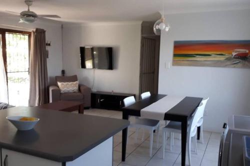 a kitchen and living room with a table and chairs at Gorgeous Self Catering Cottage off Umhlanga Rocks in Durban