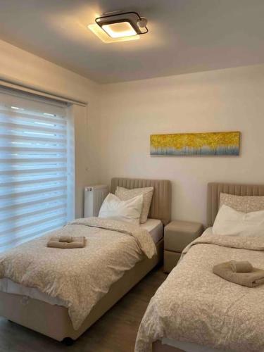 una camera con due letti e una finestra di Luxury holiday house with jacuzzi and sauna a Ostenda