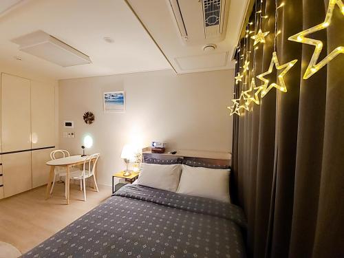 a small bedroom with a bed and a table at Secret - 고층호수공원뷰,나만의영화관,미사역2분,120인치스크린,넷플,디즈니플러스,장기숙박추천 in Hanam