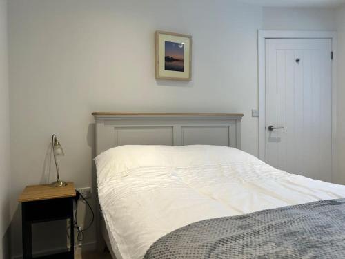 a bedroom with a bed and a table with a picture on the wall at Flat in Budleigh Salterton in Budleigh Salterton