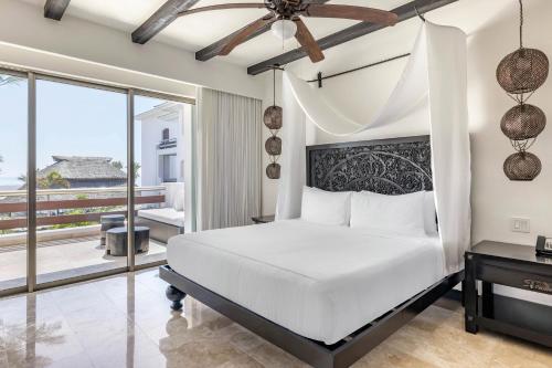 a bedroom with a white bed and a balcony at Hilton Vacation Club Cabo Azul Los Cabos in San José del Cabo