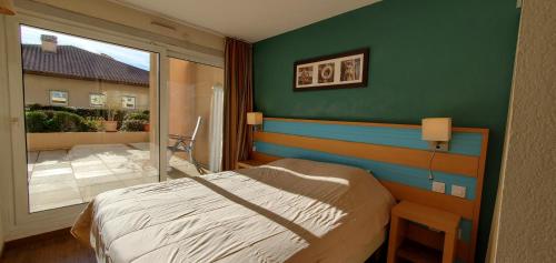 une chambre avec un lit et une grande fenêtre dans l'établissement CAP HERMES 2-3 pieces avec grande terrasse et apercu mer, à Fréjus