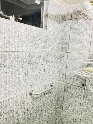 a bathroom with white tiled walls and a mirror at Sobrado Apartamento de Praia in Pontal do Paraná