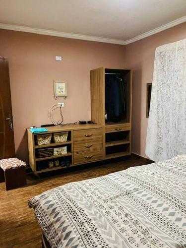 a bedroom with a bed and a dresser with a television at Sobrado Apartamento de Praia in Pontal do Paraná