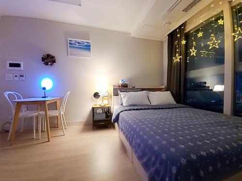 a bedroom with a bed and a table with a lamp at Secret - 고층호수공원뷰,나만의영화관,미사역2분,120인치스크린,넷플,디즈니플러스,장기숙박추천 in Hanam