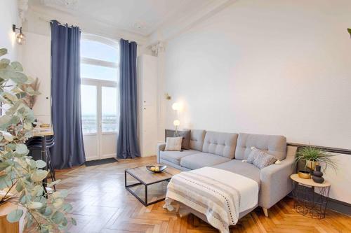 sala de estar con sofá y ventana grande en WELC'HOME IN HOULGATE - Vue et accès direct sur mer en Houlgate