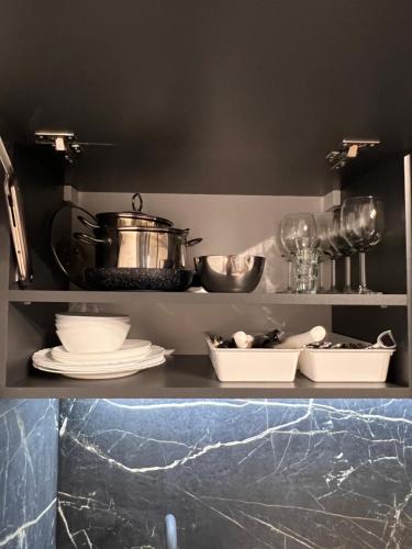 a shelf with dishes and pots and pans in a kitchen at Astro Apart in Kielce
