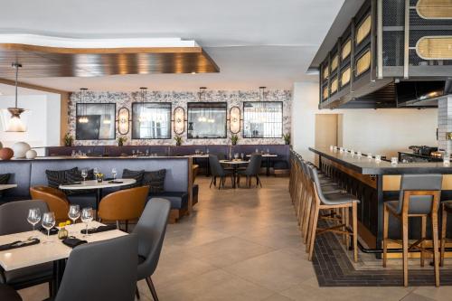 a restaurant with tables and chairs and a bar at Crowne Plaza Atlanta NE - Norcross by IHG in Norcross