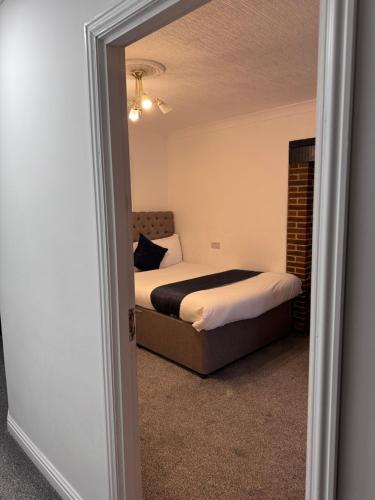 a bedroom with a bed and a mirror at All Seasons Gatwick Guest House & Parking in Horley