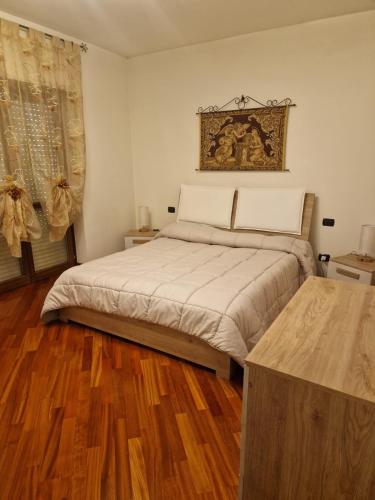 sypialnia z dużym łóżkiem i drewnianą podłogą w obiekcie LA LOGGIA DI GRAZIA w mieście Locorotondo
