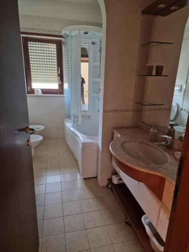 een badkamer met een bad, een toilet en een wastafel bij LA LOGGIA DI GRAZIA in Locorotondo