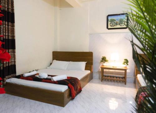 1 dormitorio con 1 cama y mesa auxiliar en Hotel White House International (Near Dhaka Medical) en Dhaka