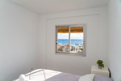 sypialnia z oknem z widokiem na plażę w obiekcie SEE THE SEA w mieście Villajoyosa