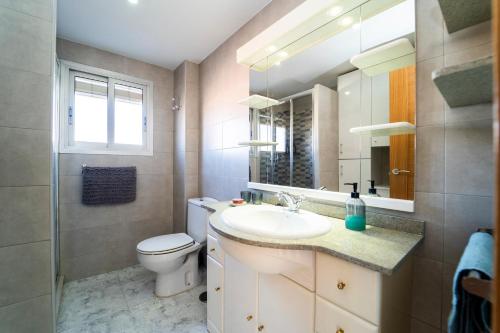 W łazience znajduje się umywalka, toaleta i lustro. w obiekcie SEE THE SEA w mieście Villajoyosa