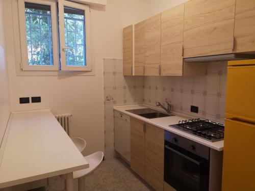 una cucina con armadi in legno e piano cottura. di Appartamento centrale e silenzioso a Casalecchio di Reno