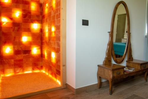 ein Badezimmer mit einem Spiegel, einem Tisch und einem Waschtisch in der Unterkunft HOTELLERIE VALLE SACRA in Cintano
