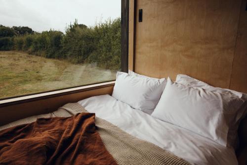 a bed sitting next to a window on a train at Re Cabins - Reconnect Cabin - St Albans 