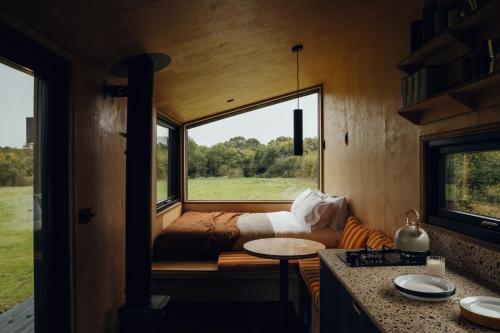 um pequeno quarto com uma cama e uma janela em Re Cabins - Reconnect Cabin - St Albans 
