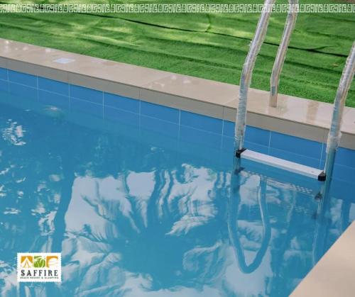 a swimming pool with a reflection in the water at Saffire Beach Resort and Glamping in Pagudpud