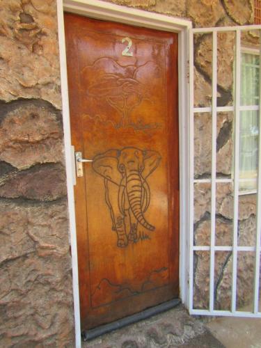 a drawing of an elephant on a wooden door at POVI Holiday Home in Kasane