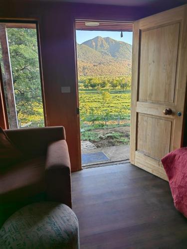 een kamer met een deur en uitzicht op een berg bij Entre saltos in Lonquimay