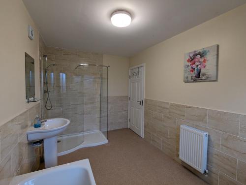 uma casa de banho com um lavatório, um chuveiro e um WC. em Orchard House em Scarborough