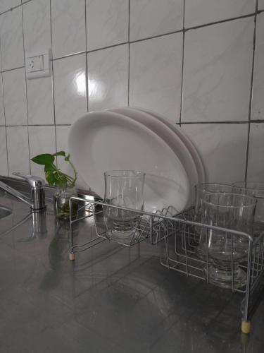 un étendoir à vaisselle avec des verres sur un comptoir dans l'établissement Carileufu, à Comandante Luis Piedrabuena