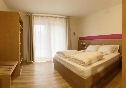 sypialnia z dużym łóżkiem i oknem w obiekcie Rifugio Pian dei Ciclamini w mieście Lusevera