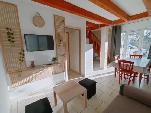 a living room with a table and a tv at La Cour des Miracles in Vallon-Pont-dʼArc