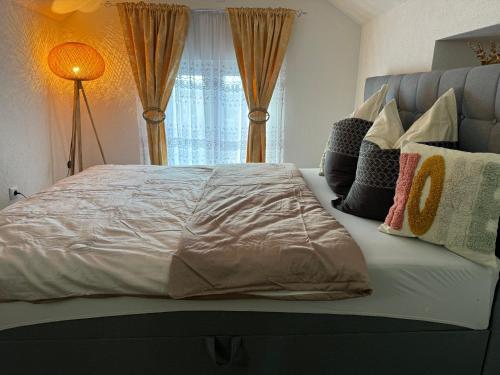 - un grand lit avec des oreillers dans la chambre dans l'établissement Studio apartman Cuprija, à Cazin