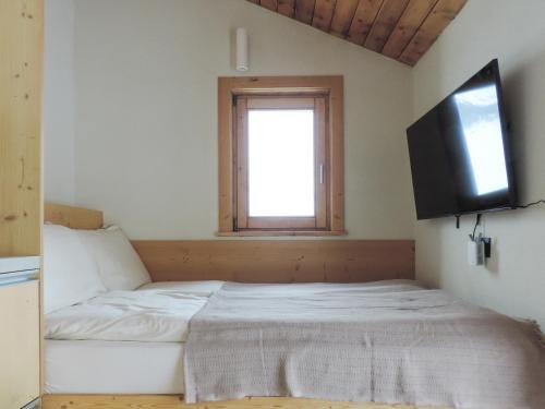 - une chambre avec un lit et une télévision murale dans l'établissement Stilla Mini Room, à Livigno