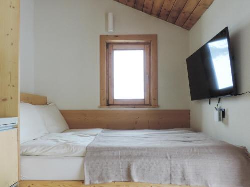 a bedroom with a bed and a television on the wall at Stilla Mini Room in Livigno