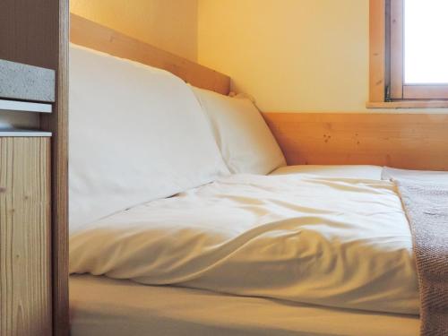a white bed in a room with a window at Stilla Mini Room in Livigno