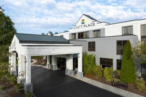 a white hotel with an archway in front of it at Hyatt Place Mystic in Mystic