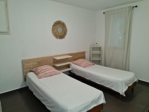 Cette chambre comprend 2 lits et un miroir mural. dans l'établissement Le Moulin, à Grasse